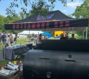 Pit smoker and tent at backyard BBQ catering event